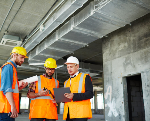 Operai in cantiere in Sardegna con DPI, lavorando in sicurezza