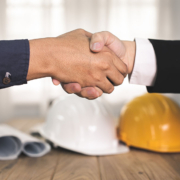 Stretta di mano con caschi da lavoro, simbolo di una partnership per la sicurezza aziendale